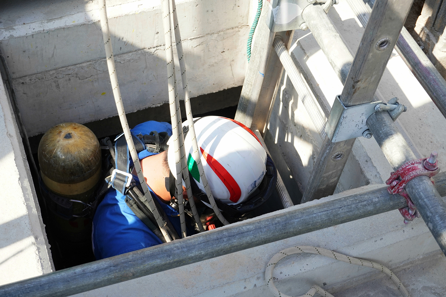 a person going down a ladder into a confirmed space